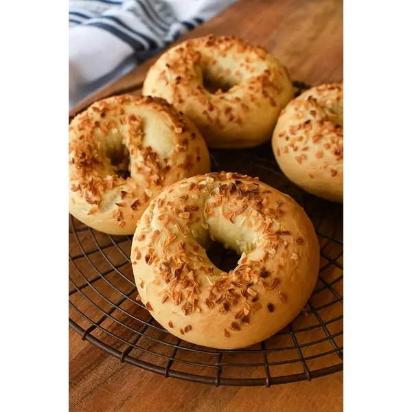 Onion Bagel: Easy, High-Protein, Homemade Perfection 7 Sliced onion bagel topped with scrambled eggs and fresh herbs