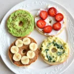 5 Bagel Toppings: The Best Deliciously Easy Ways to Power Your Day 8 Five high-protein bagel toppings on a serving board with hummus, egg salad, yogurt spread, ricotta, and peanut butter.