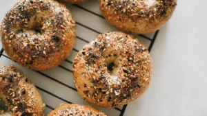 close-up of golden everything bagel topped with sesame, poppy seeds, and garlic on