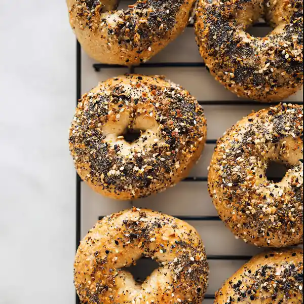 Everything Bagel You’ll Love, Easy, Homemade & High Protein 19 golden brown everything bagels topped with poppy seeds, sesame, and spices on cooling rack
