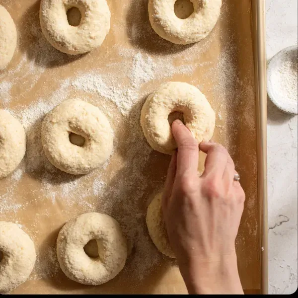 These Protein Bagels With Almond Flour Are So Good, Even the Kids Ate Them 14 hand shaping protein almond flour bagels on floured parchment-lined baking tray before baking
