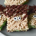 Frankenstein Rice Krispies Treats 5 Frankenstein-inspired rice krispie treats with chocolate hair and candy eyes on marble plate