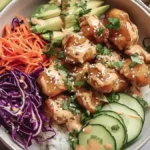 Bang Bang Chicken Bowl 5 colorful rice bowl with crispy cauliflower, avocado, shredded carrots, red cabbage, cucumber, sesame seeds
