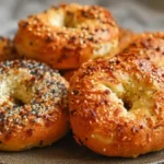 High Protein Bagel with Greek Yogurt Recipe You’ll Actually Crave 17 Freshly baked High Protein Bagel with Greek Yogurt topped with sesame, and poppy seeds on a ceramic plate