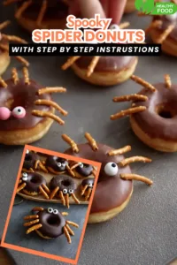 chocolate-glazed spider donuts with candy eyes and pretzel legs on gray table