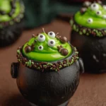 chocolate cauldron cupcakes filled with green frosting and candy monster eyes