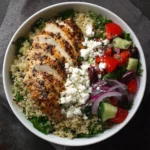 grilled chicken quinoa bowl with cherry tomatoes, cucumbers, kalamata olives, red onion, and feta