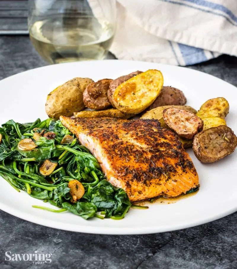 Skillet blackened salmon with spinach and garlic on a plate