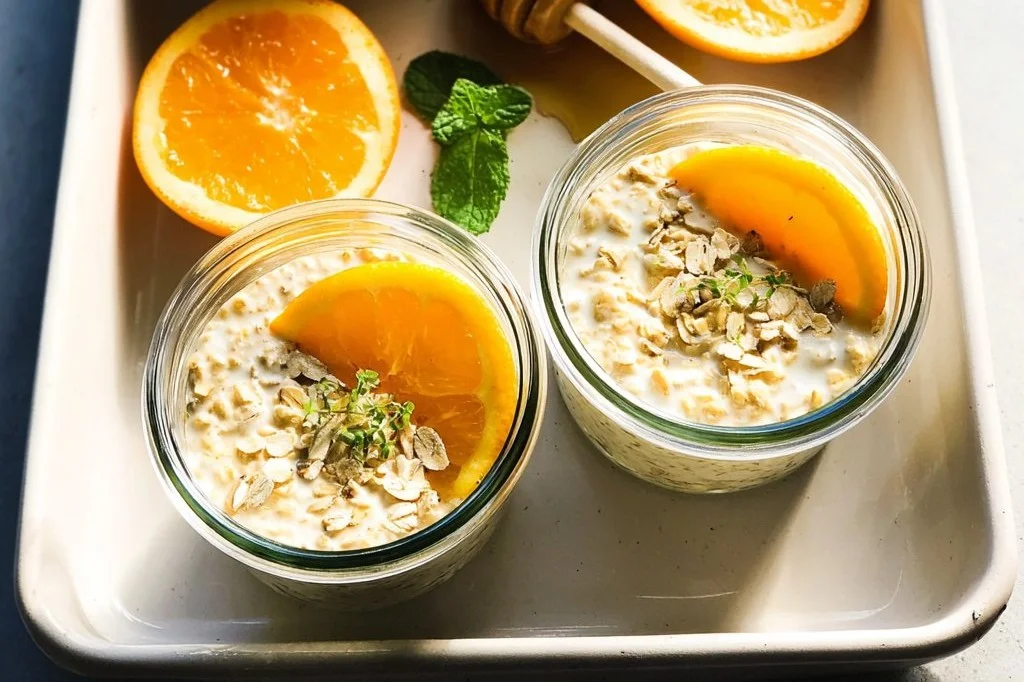 High-protein orange vanilla protein overnight oats in a jar with fruits