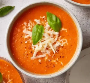 High protein tomato soup in a bowl with fresh herbs and crusty bread