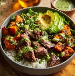 Juicy steak and sweet potato bowl garnished with fresh herbs