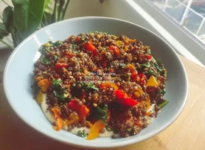 High-protein lentil quinoa bowl with fresh vegetables and herbs